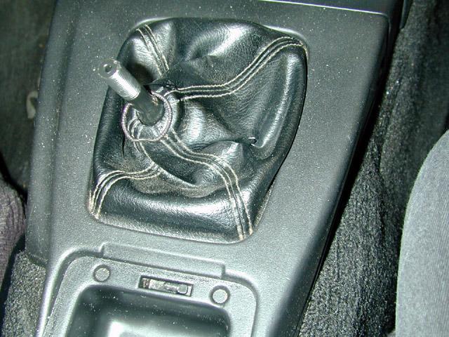 Unscrew the shift knob and the two screws on either side at the front of the console.